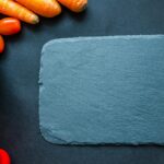 Colorful vegetables on a slate board, perfect for healthy cooking themes.