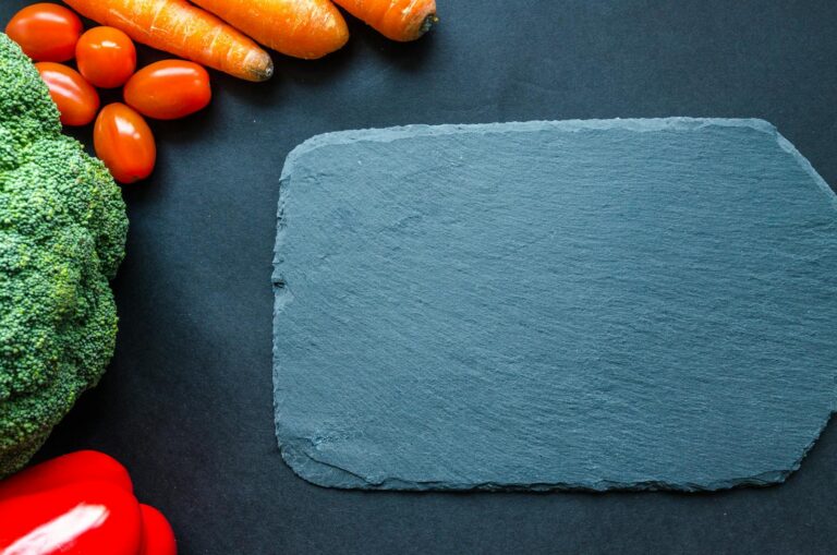 Colorful vegetables on a slate board, perfect for healthy cooking themes.